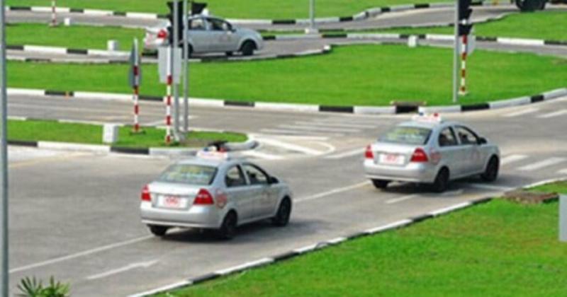 Một người hướng dẫn đang dạy kỹ năng lái xe an toàn cho một học viên tại trung tâm đào tạo sát hạch lái xe ở Việt Nam
