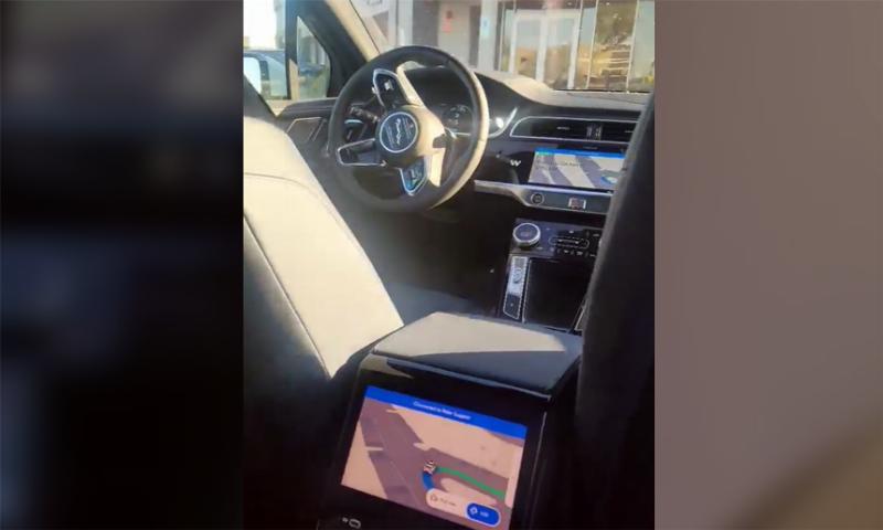 Xe Vinfast taxi màu xanh đậu gần một biển báo giao thông có biển số 90, gợi ý về sự hiện diện của xe điện taxi tại Đồng Nai hoặc các tỉnh lân cận