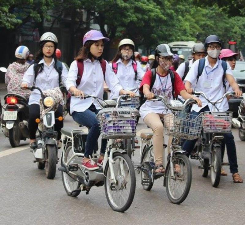 Hình ảnh phụ huynh hướng dẫn con em về quy định và an toàn khi sử dụng xe đạp điện