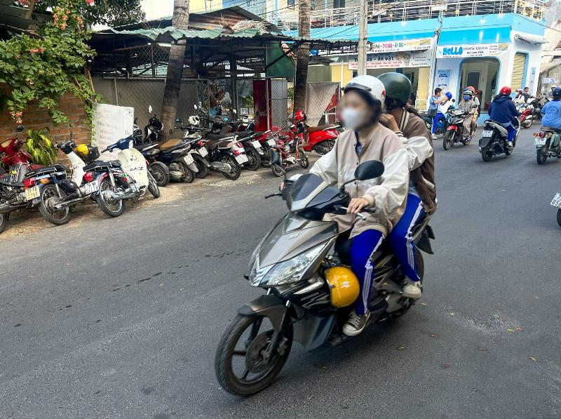 Hình ảnh cha mẹ hoặc người lớn đang hướng dẫn con cách điều khiển xe đạp hoặc xe đạp điện một cách an toàn, nhấn mạnh vai trò của gia đình trong giáo dục an toàn giao thông cho trẻ vị thành niên