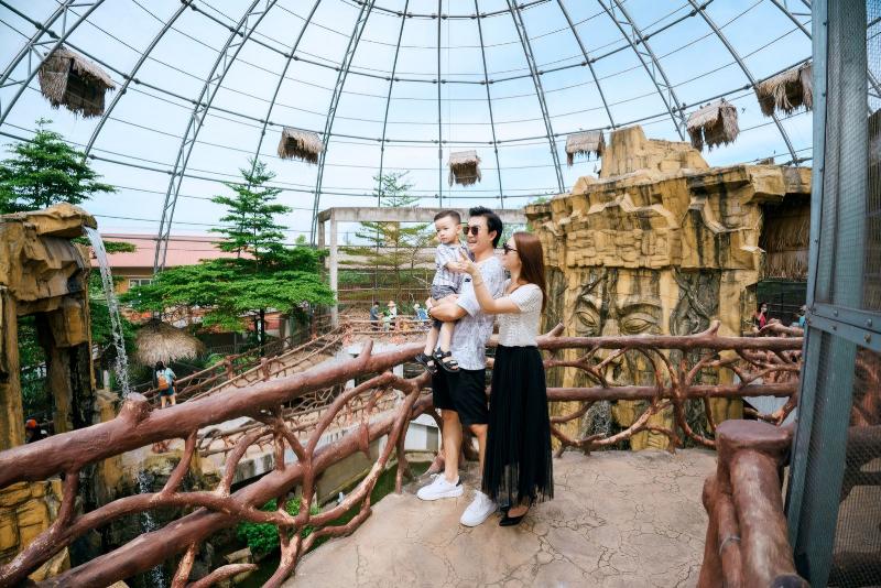 Một gia đình đang vui vẻ cùng nhau trải nghiệm xe điện thăng bằng trong công viên vào buổi chiều mát.