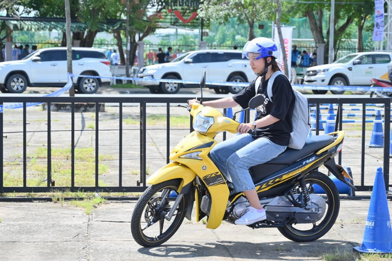 Một người mới tập đang được hướng dẫn cách bước lên và giữ thăng bằng trên xe điện thăng bằng hai bánh.