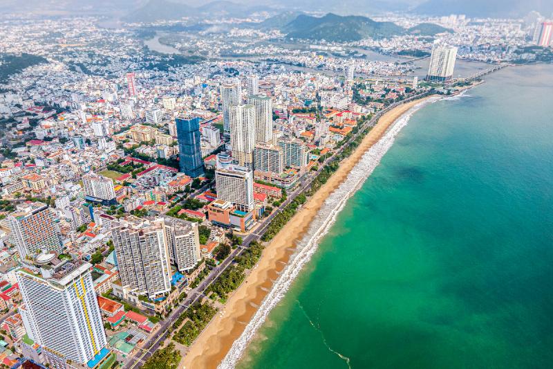 Xe taxi Vinfast đậu bên bãi biển Nha Trang, biểu tượng cho di chuyển xanh và hiện đại tại thành phố biển này